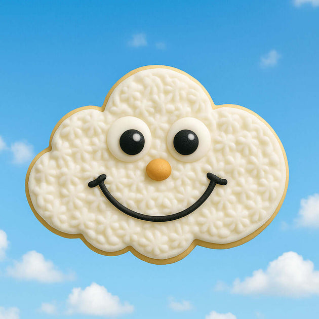Cloud-shaped cookie with a face on a blue sky background from a 2 inch Mini Cloud Metal Cookie Cutter
