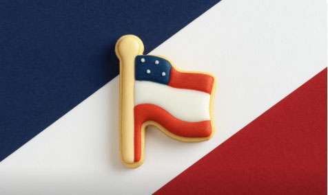 Cookie shaped like a letter 'H' with American flag design on a red, white, and blue striped background from a 2 inch Mini Flag Metal Cookie Cutter