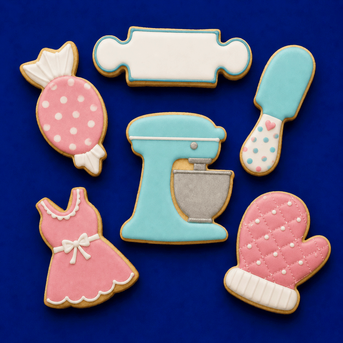 Decorative cookies shaped like kitchen utensils and a apron on a blue background from a Set of Baking Metal Cookie Cutters