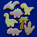 Decorative cookies shaped like dinosaurs and a palm tree on a blue background from a  Set of Dinosaur Metal Cookie Cutters