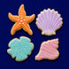 Four decorative cookies shaped like a starfish, shell, and two different types of shells on a blue background from a Set of Shells Sand Dollar and Starfish Metal Cookie Cutters