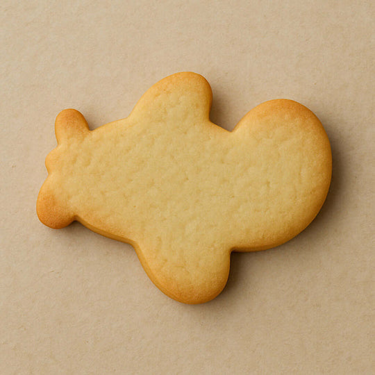 Plain airplane-shaped cookie on a beige backgroundfrom a 4 inch Airplane Metal Cookie Cutter
