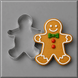 A 5 inch Gingerbread Boy Metal Cookie Cutter shown beside a decorated gingerbread man cookie on a smooth gray surface.