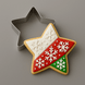 Decorative star-shaped cookie with snowflake design next to a metal star-shaped cookie cutter on a gray background from a 2.5 inch Star Metal Cookie Cutter