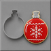 A 4 inch Christmas Ornament Metal Cookie Cutter shown next to a decorated Christmas ornament-shaped sugar cookie with red icing, white icing details, and a gold-toned edge, on a smooth gray background.