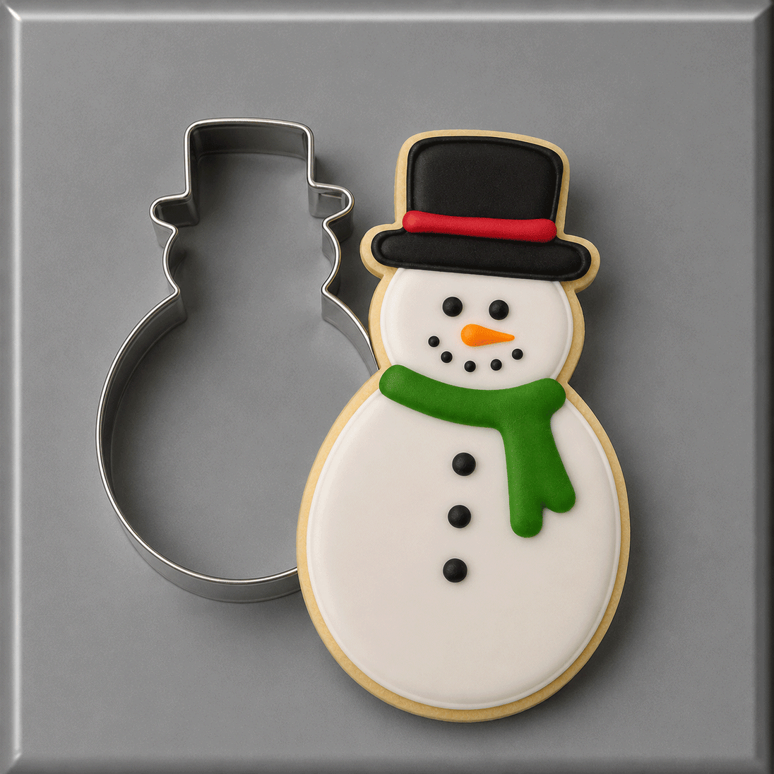 Snowman cookie with a 5 inch Snowman Metal Cookie Cutter along side it.