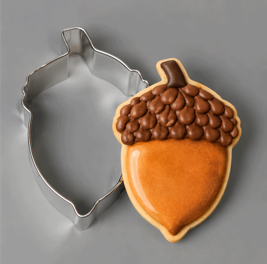 An acorn decorated cookie along side a 2.75 inch Acorn Metal Cookie Cutter