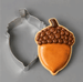 An acorn decorated cookie along side a 2.75 inch Acorn Metal Cookie Cutter