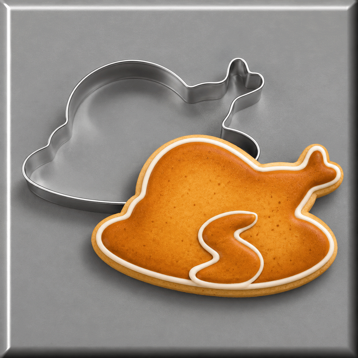 A cooked turkey cookie next to a 4.5 inch Thanksgiving Turkey Dinner Metal Cookie Cutter