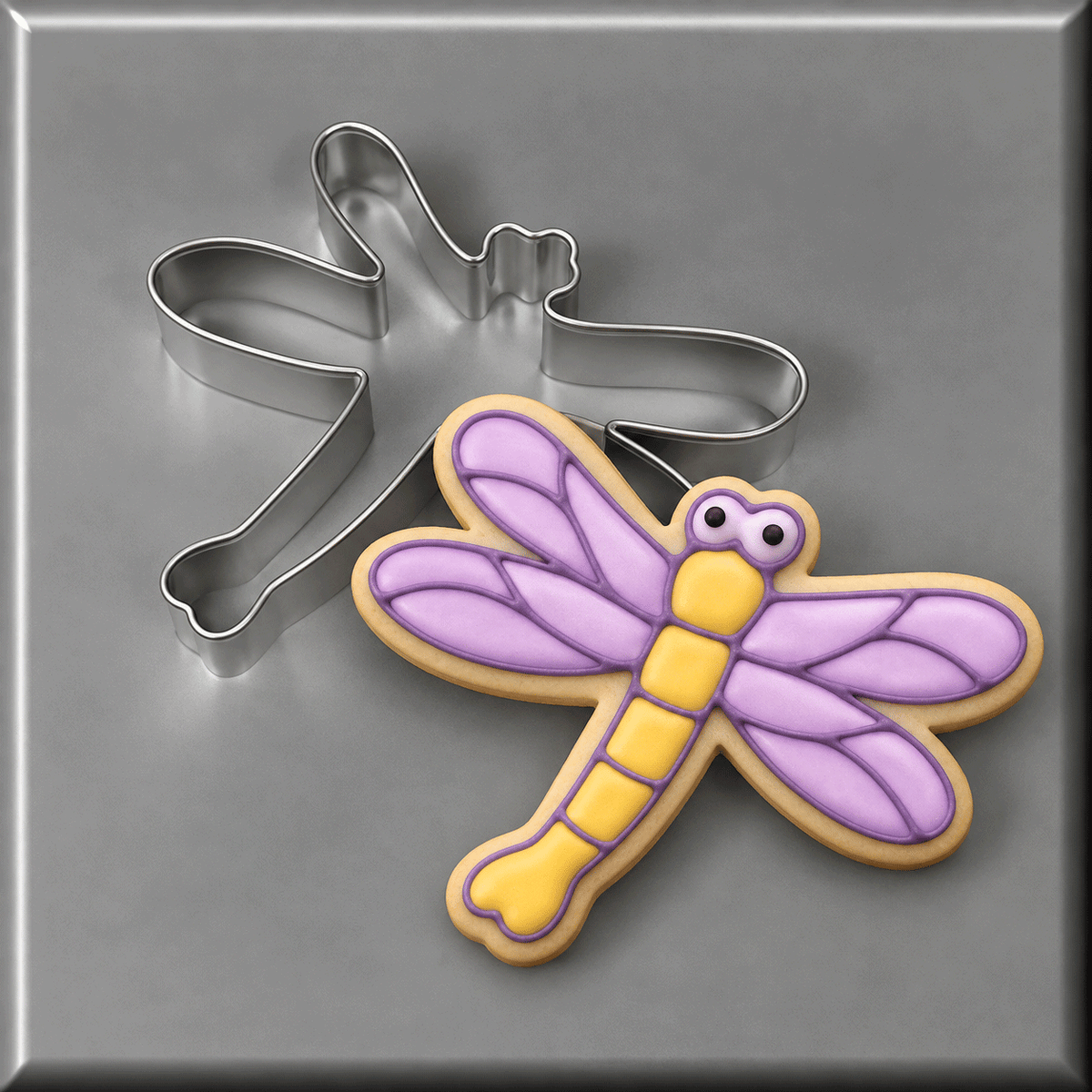 Purple and yellow dragonfly decorated cookie and a 3.5 inch Dragonfly Metal Cookie Cutter