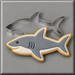 A shark-shaped sugar cookie with gray, white, and tan icing, shown with a 4 inch Shark Metal Cookie Cutter on a gray background.