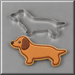 A 5 inch Primitive Dachshund Metal Cookie Cutter above a decorated dachshund-shaped sugar cookie on a gray background.