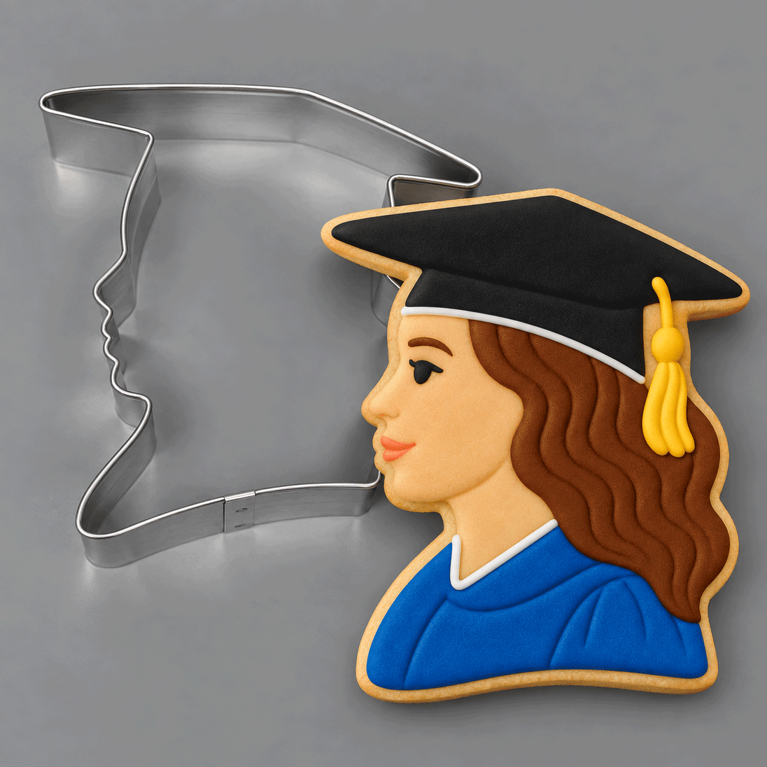 Cookie decorated as a grad girl next to a 3.75 inch Graduation Girl Metal Cookie Cutter