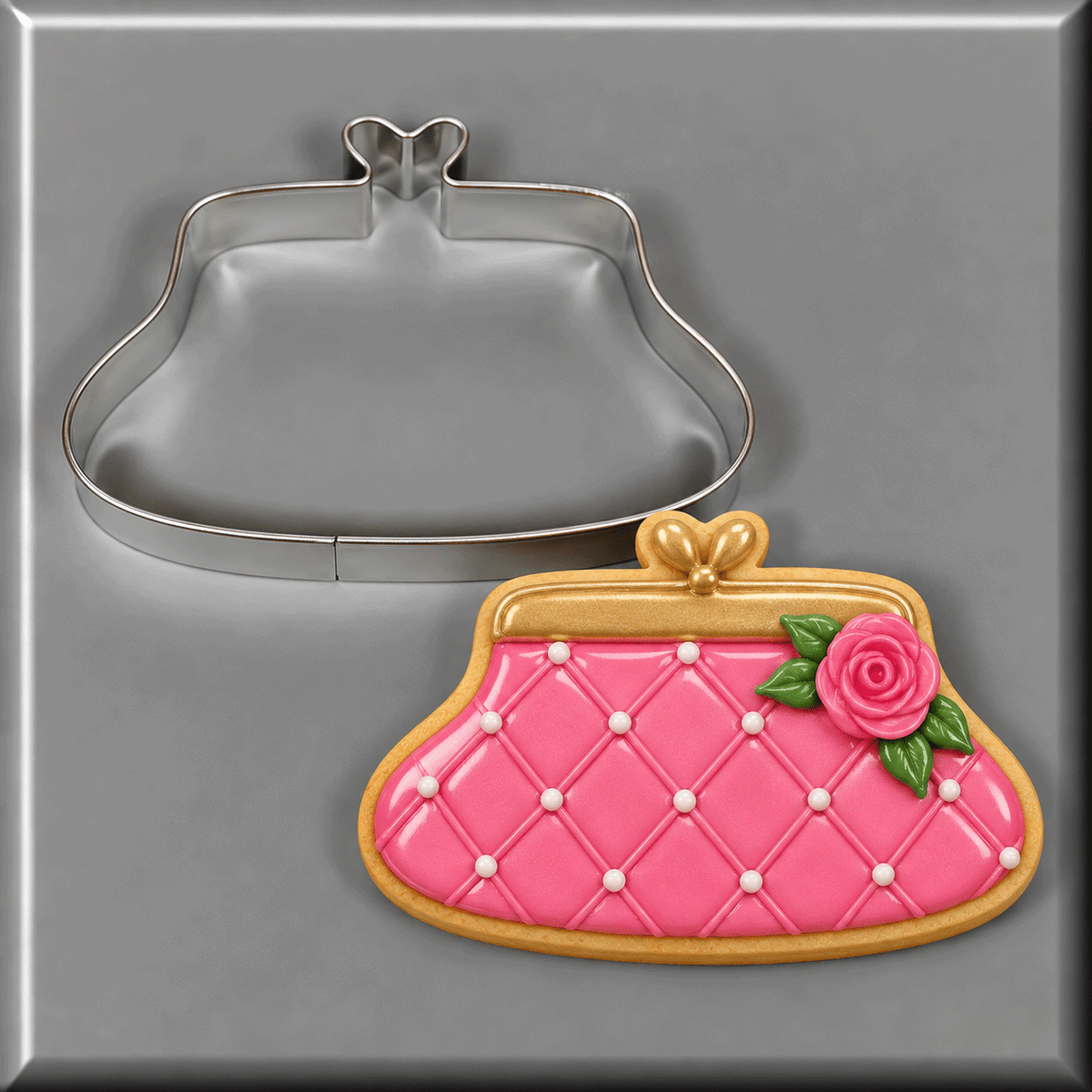 A pink and gold purse cookie next to a 4 inch Purse Metal Cookie Cutter