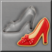 A red high-heeled shoe-shaped cookie with a white polka-dot bow and beige icing outline, shown next to a 4 inch Shoe or Slipper With Bow Metal Cookie Cutter on a gray background.