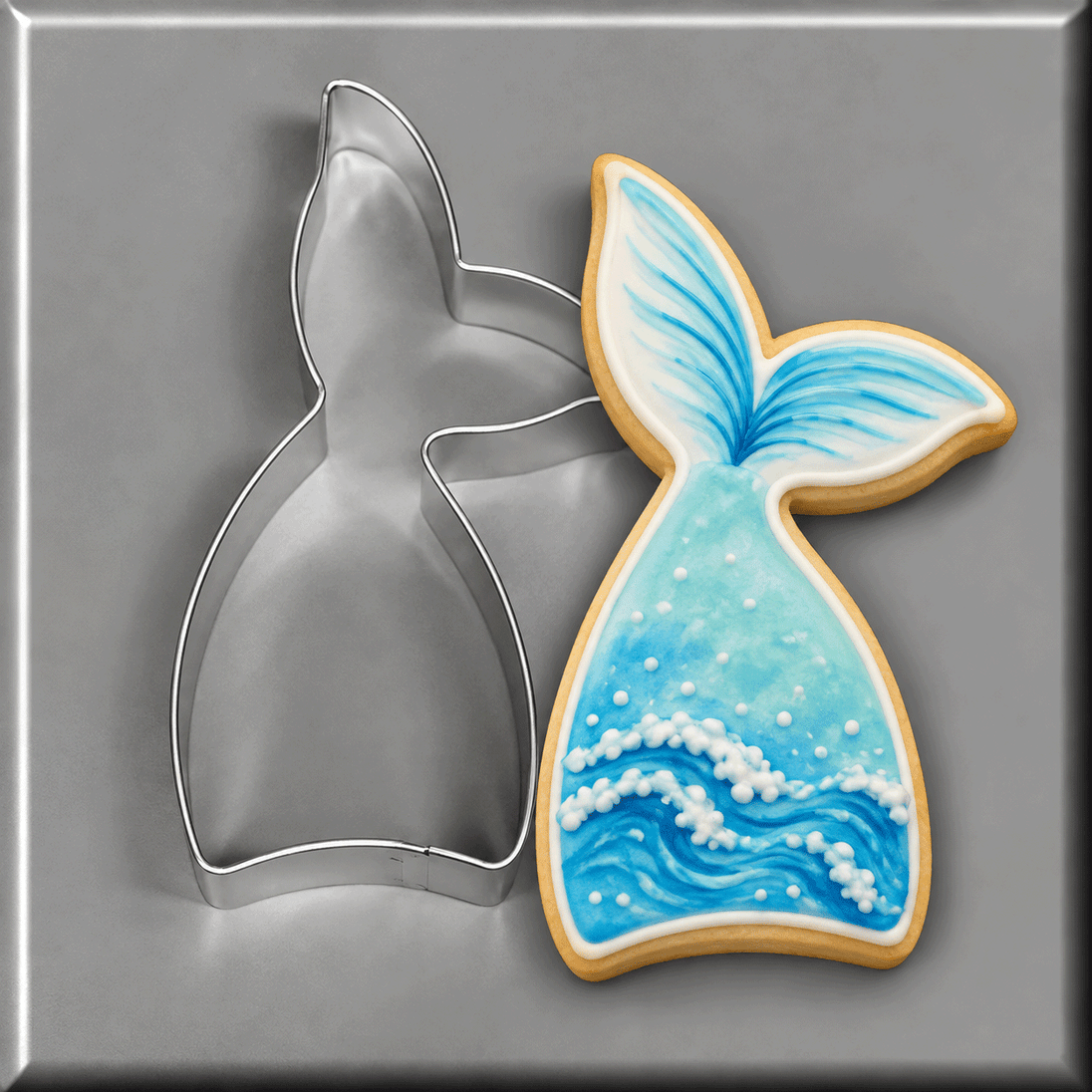A blue and white mermaid tail cookie with it's matching 4 inch Mermaid Fish Tail Metal Cookie Cutter