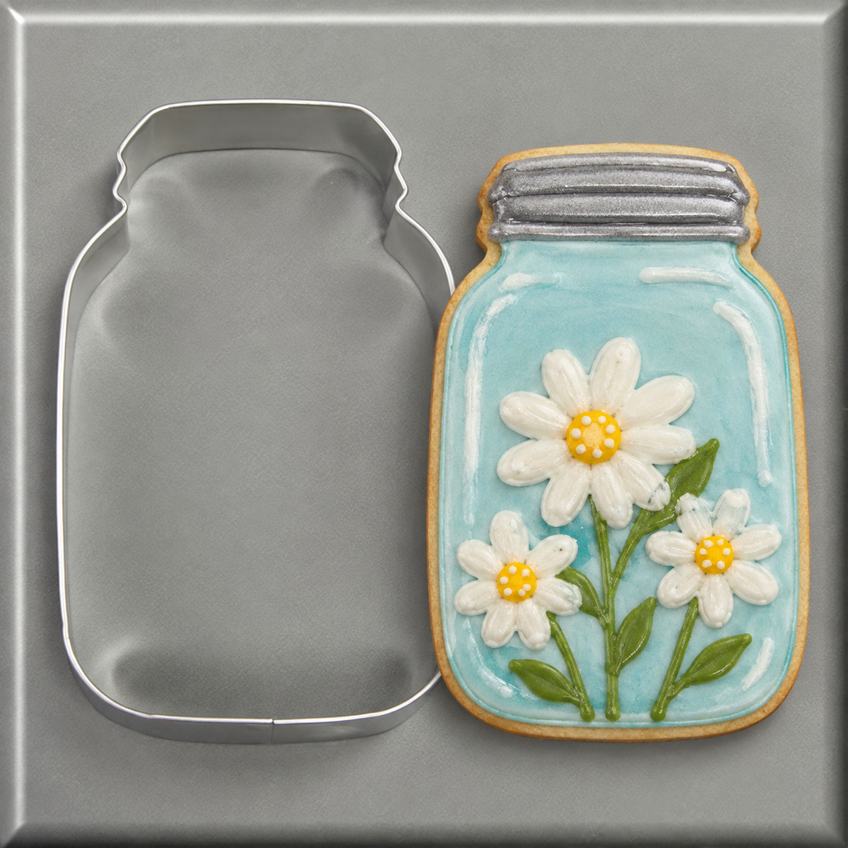 A flowered mason jar cookie and a 4.5 inch Mason Jar Metal Cookie Cutter