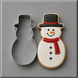 A 4.5 inch Snowman Metal Cookie Cutter shown next to a decorated snowman cookie on a smooth gray surface.