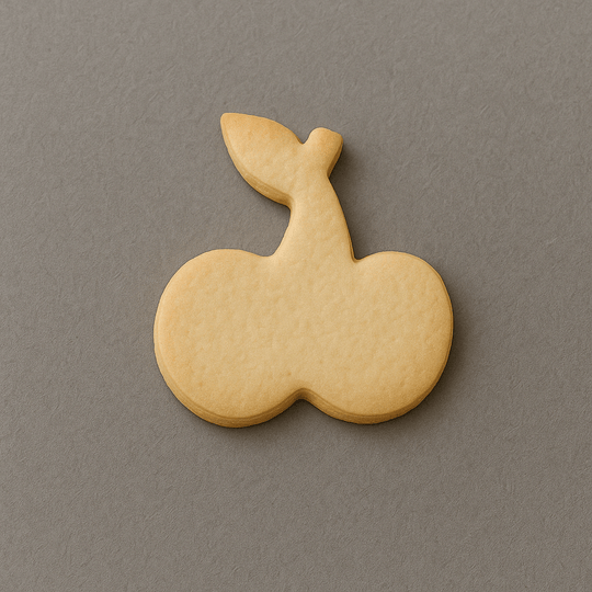 Cookie shaped like a cherry on a gray background from a 3.5 inch Cherries Metal Cookie Cutter