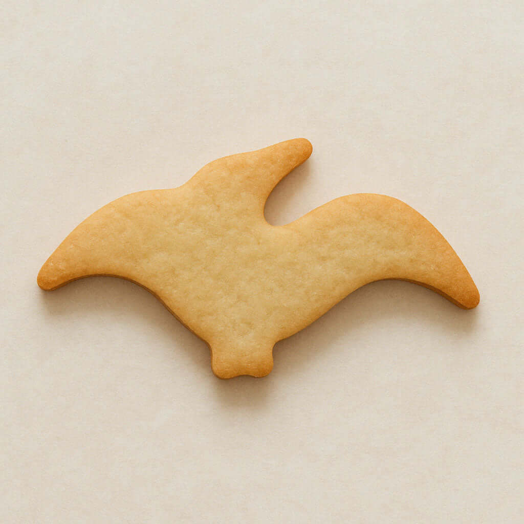 Biscuit shaped like a pterodactyl  on a beige background from a 4.75 inch Pterodactyl Metal Cookie Cutter